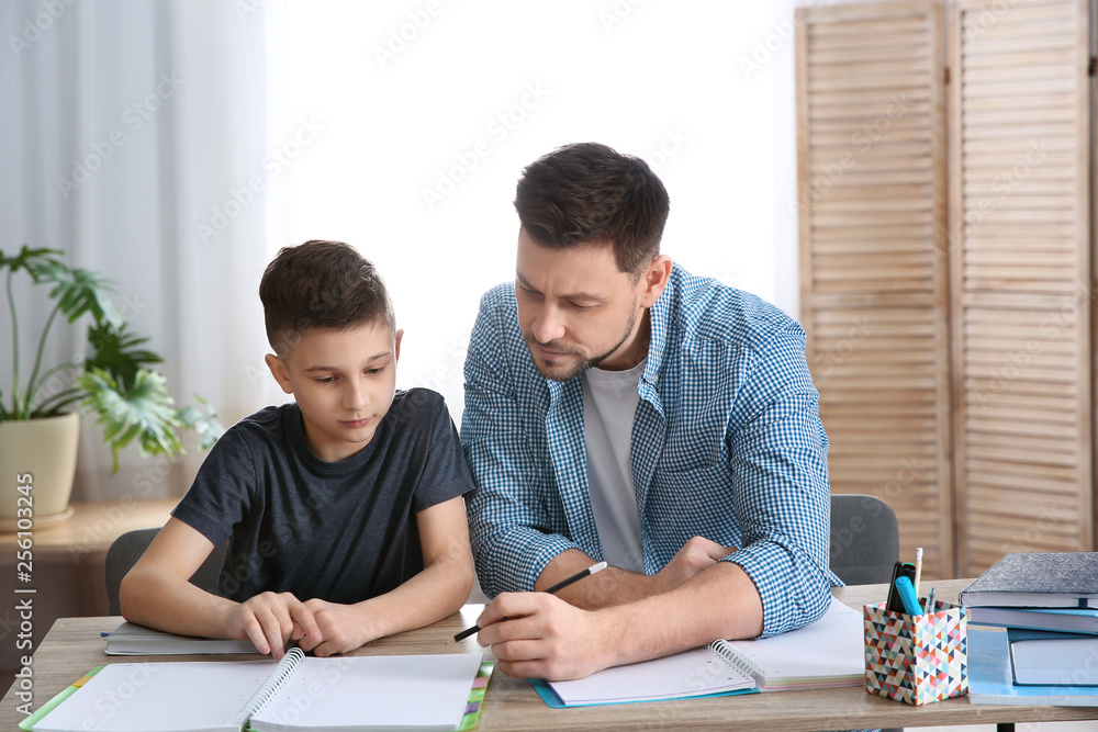 Dad helping his son with homework in room Dad helping his son with homework in room