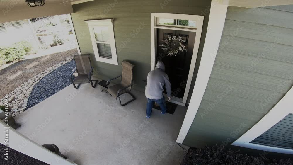 Home security camera catches thief stealing packages from front porch.