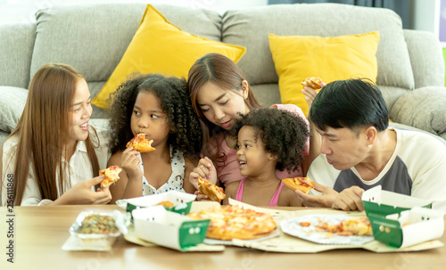 international family of happy man ,woman and children. They are having party at home, eating pizza and having fun. leisure, food and drinks, people and holidays concept. Ethnic diversity,Host family