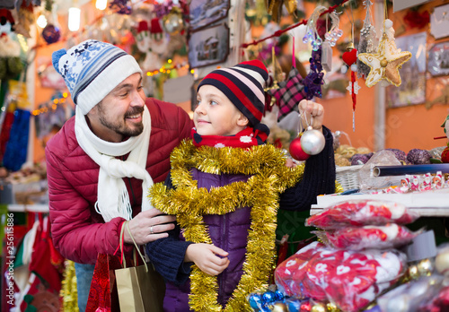 Little girl with dad buying decorations for Xmas