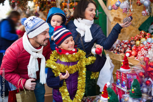 Parents with kids choosing X-mas decorations in market