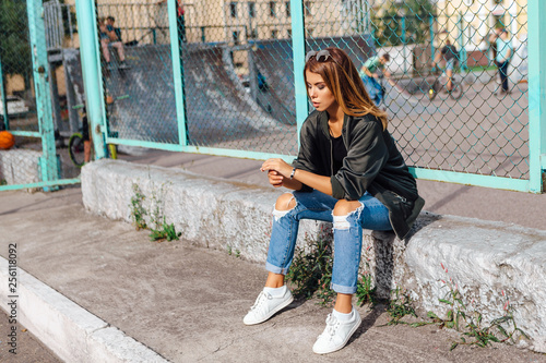 Fashion portrait of trendy young woman wearing sunglasses, and bomber jacket sit Fototapete