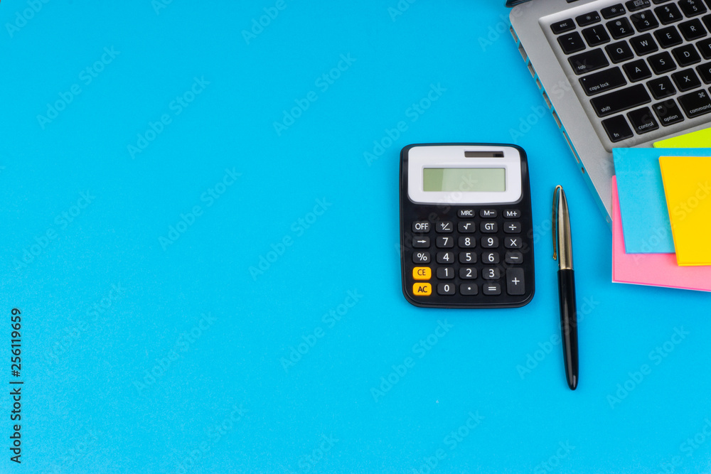 Flat lay, top view office table desk. Workspace with calculator, black pen, laptop on the turqoise blue background. Business Finance,Education Technology and Copy Space for text concept Flat lay, top view office table desk. Workspace with calculator, black pen, laptop on the turqoise blue background. Business Finance,Education Technology and Copy Space for text concept