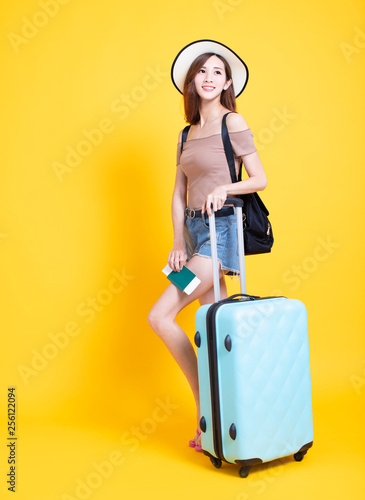 happy tourist woman in summer hat with passport and suitcase