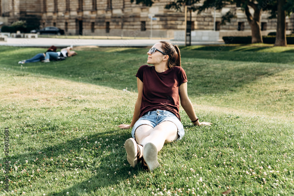 Φωτογραφία Beautiful young girl resting on the grass on the street in Leipzig in Germany
