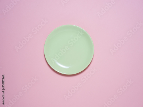 A green plate on a pink background with an Easter decoration.