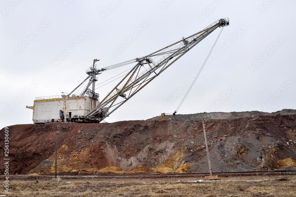 Large walking excavator in anticipation of rolling stock transporting overburden for storage in dumps. Large walking excavator in anticipation of rolling stock transporting overburden for storage in dumps.