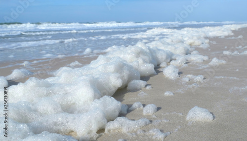 White Sea foam blown by strong on-shore winds to the Kampen beach in Sylt island, Germany. A global phenomenon of the ocean. Algal blooms and dissolved organic matter  in the ocean are churned up.