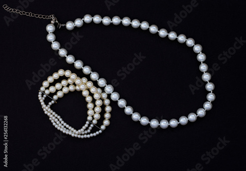women's jewelry with pearls on black background