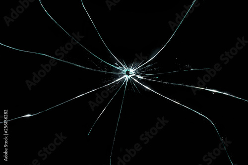 broken cracked glass with hole in black background