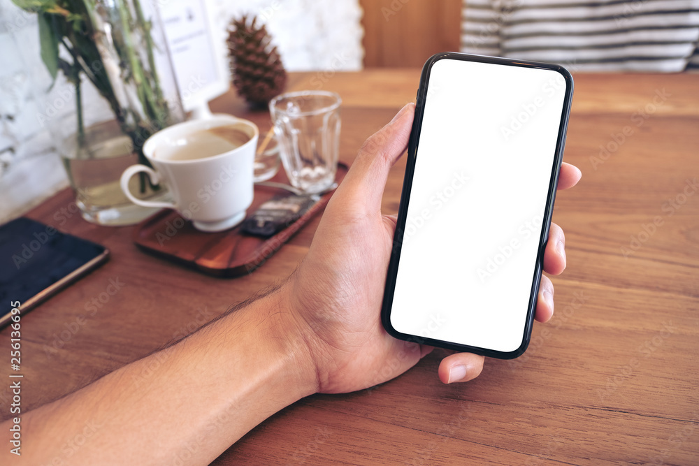 Mockup image of a man's hand holding black mobile phone with blank screen with woman in cafe Mockup image of a man's hand holding black mobile phone with blank screen with woman in cafe