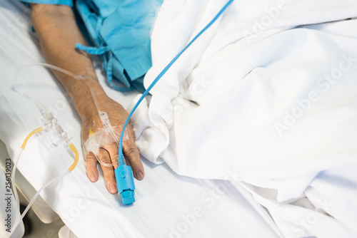 Vászonkép Close up old woman patient hand and iv set for fluid intravenous drop saline drip on white hospital bed background in the hospital room