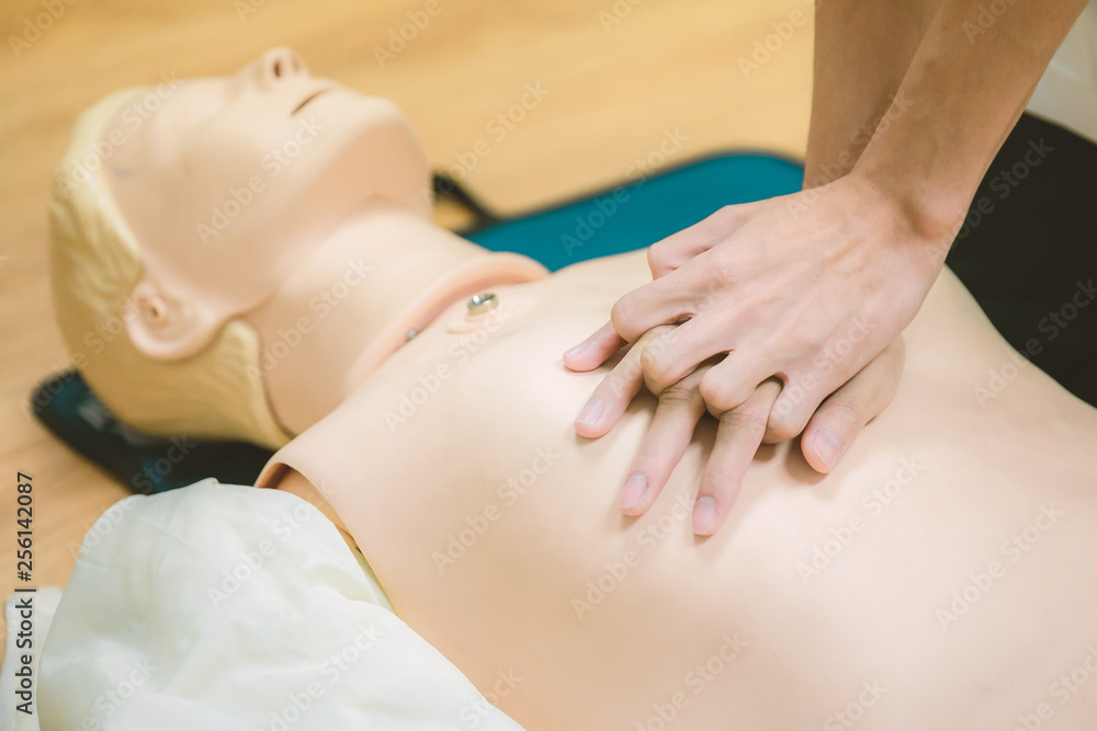 CPR training medical procedure - Demonstrating chest compressions on CPR doll in the class CPR training medical procedure - Demonstrating chest compressions on CPR doll in the class
