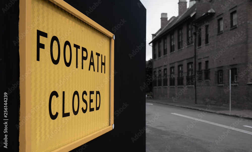 Footpath closed sign on a black fence