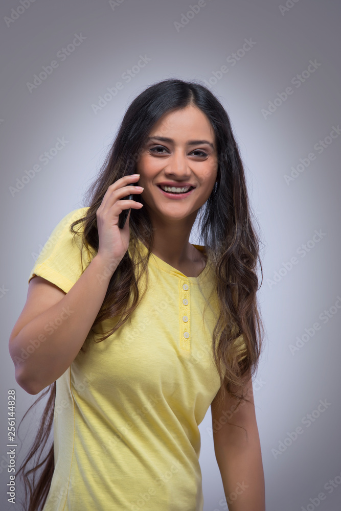 Portrait of a smiling young girl talking over mobile phone Portrait of a smiling young girl talking over mobile phone