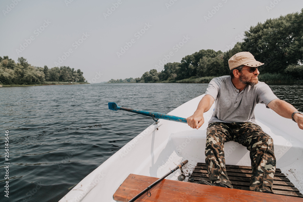 man with beard rowing on rowing boat