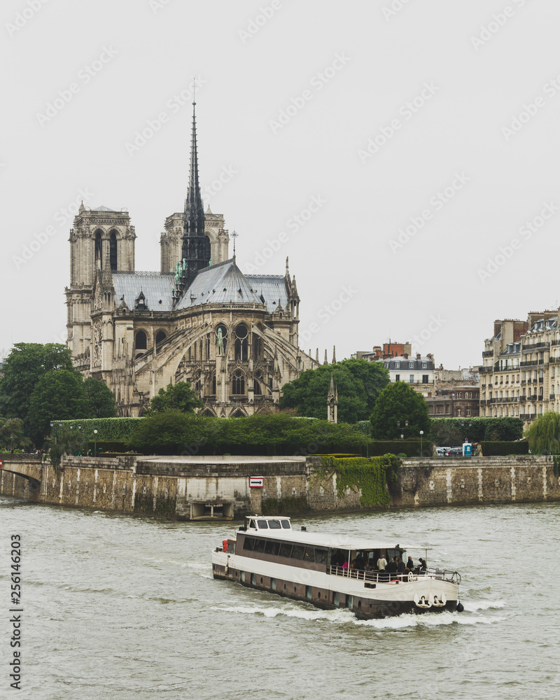 Notre Dame Cathedral by Seine River with boat in Paris, France