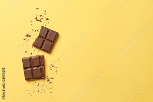 Fotografiet Sweet tasty chocolate on color background