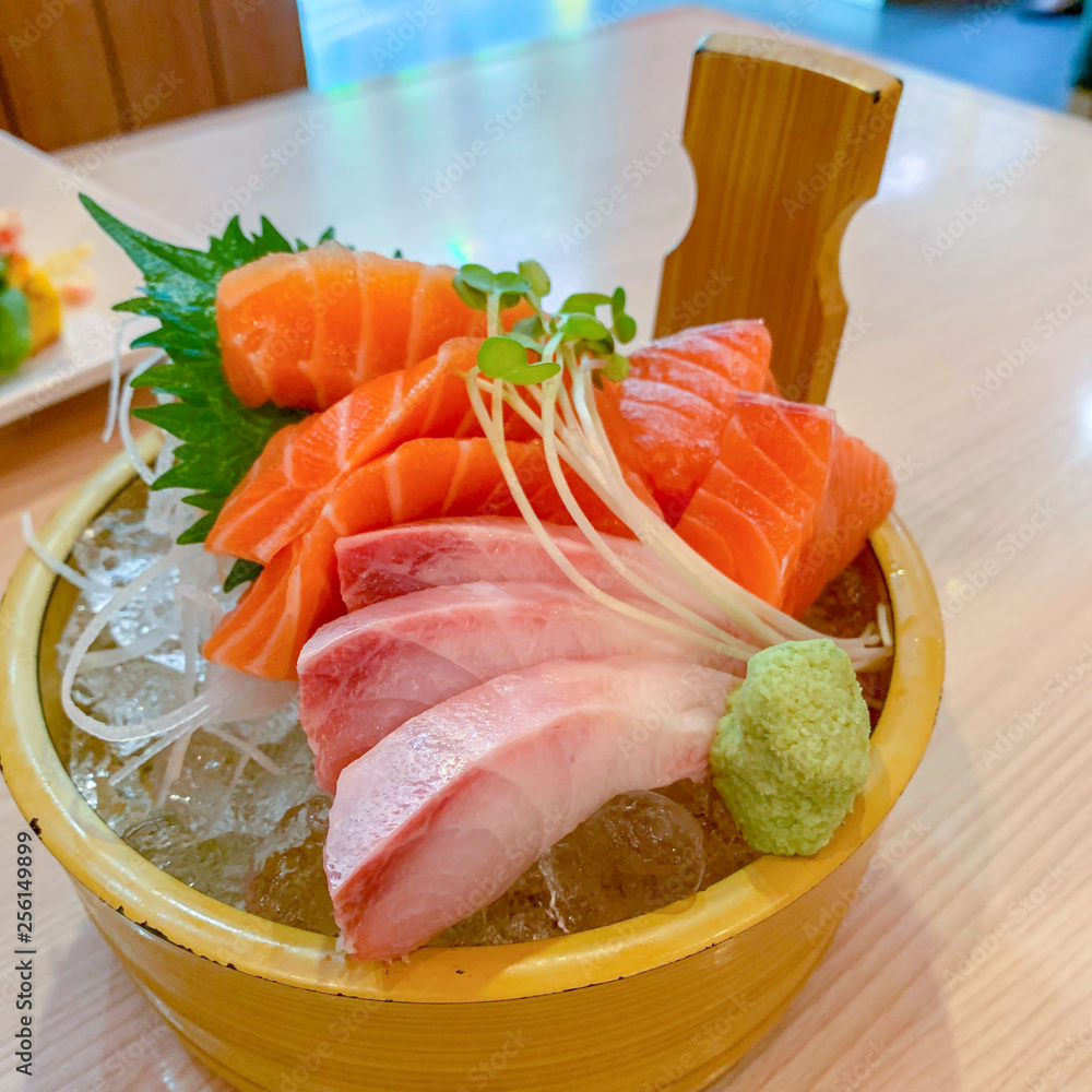 Salmon, tuna, sashimi included on the ice, using wooden containers Bring along with Wasabi in a Japanese restaurant. Salmon, tuna, sashimi included on the ice, using wooden containers Bring along with Wasabi in a Japanese restaurant.