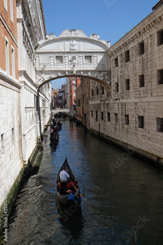View of one of little canals with gondolas and historical buildings in Venice, Italy 