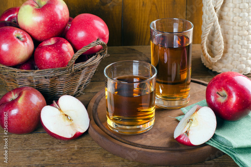 Apple juice in glasses and red apples.