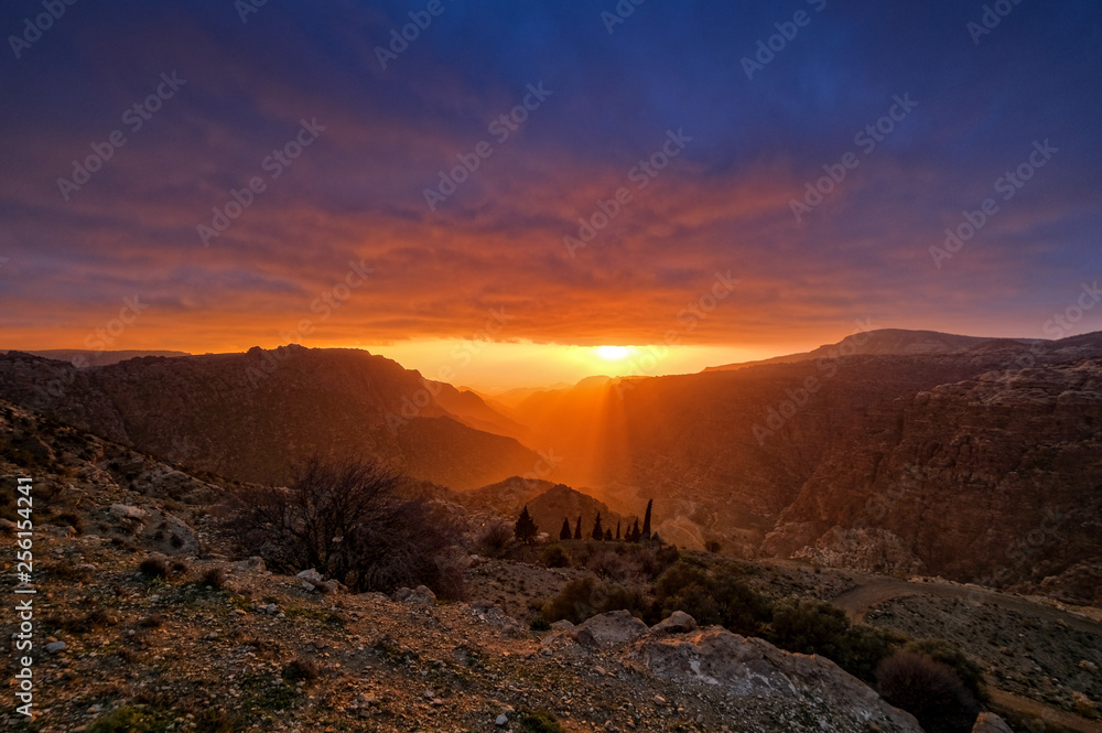 Dramatic orange sunset in Dana mountains in Jordan