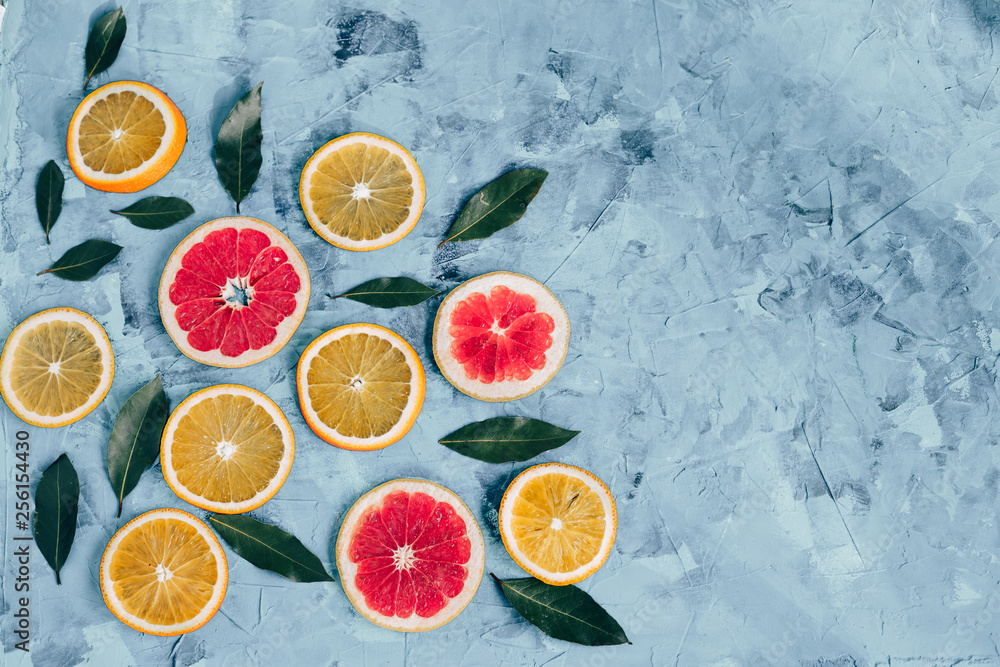 The composition of orange slices and grapefruit on a gray table top view The composition of orange slices and grapefruit on a gray table top view