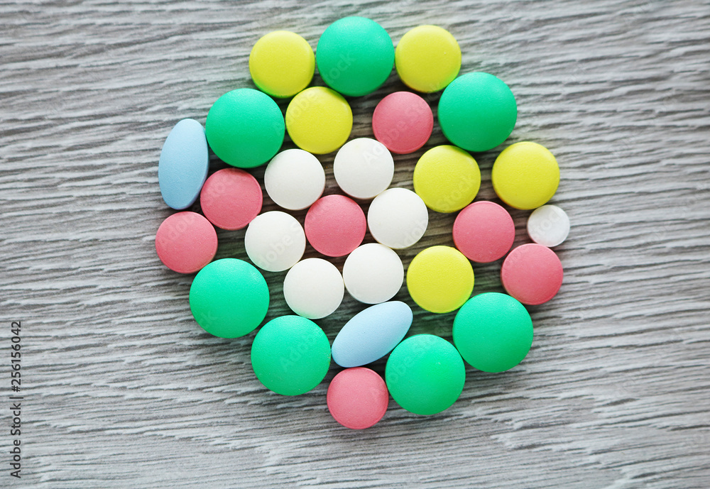 A lot of multi-colored tablets of different shapes. Pills are used in medicine to heal people. A lot of multi-colored tablets of different shapes. Pills are used in medicine to heal people.