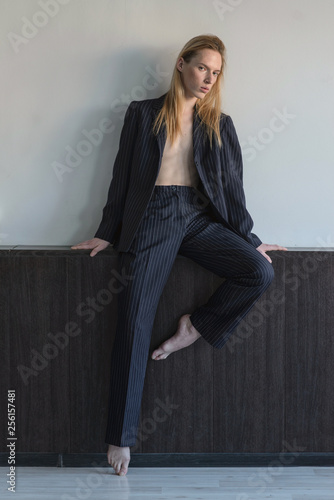 Portrait of a young attractive man. .Androgyn model sits on the eaves.