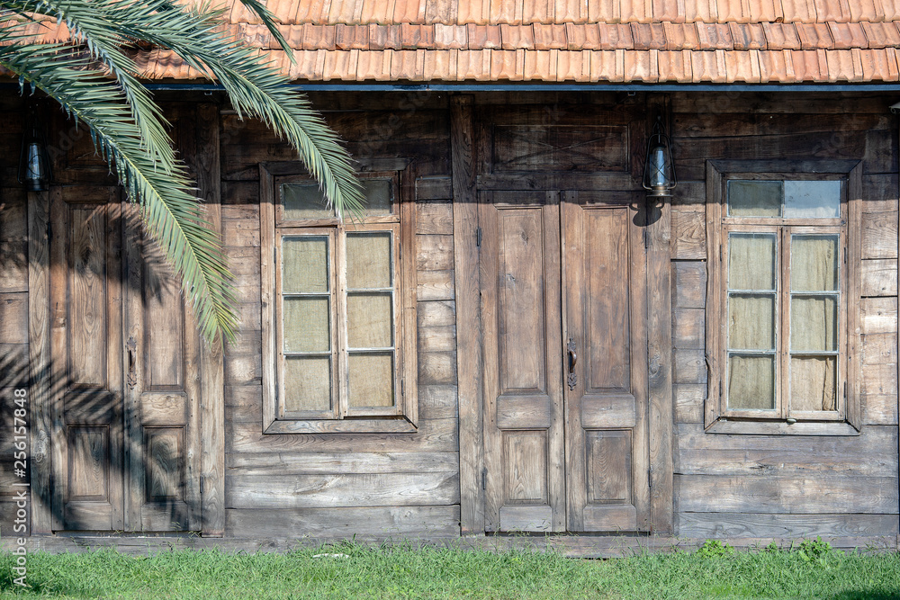 Facade of an old wooden house. Background of the wooden wall of the house Facade of an old wooden house. Background of the wooden wall of the house