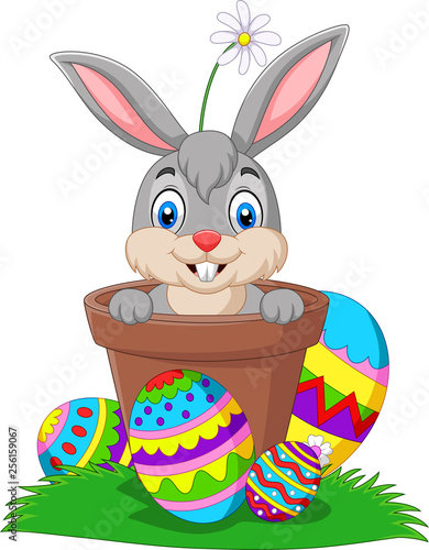 Cartoon bunny in the pot with Easter eggs on the grass