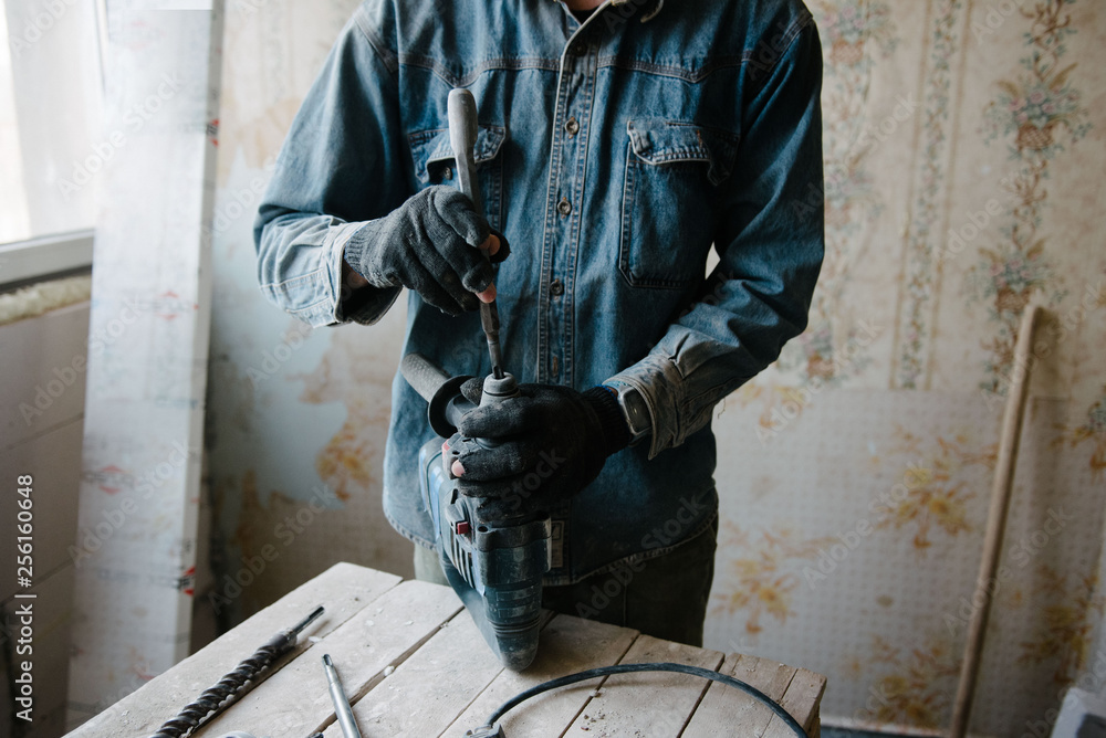 A man changes the bit on the punch