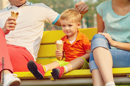 outdoor portrait of a family. Mom, dad and child eating ice cream
