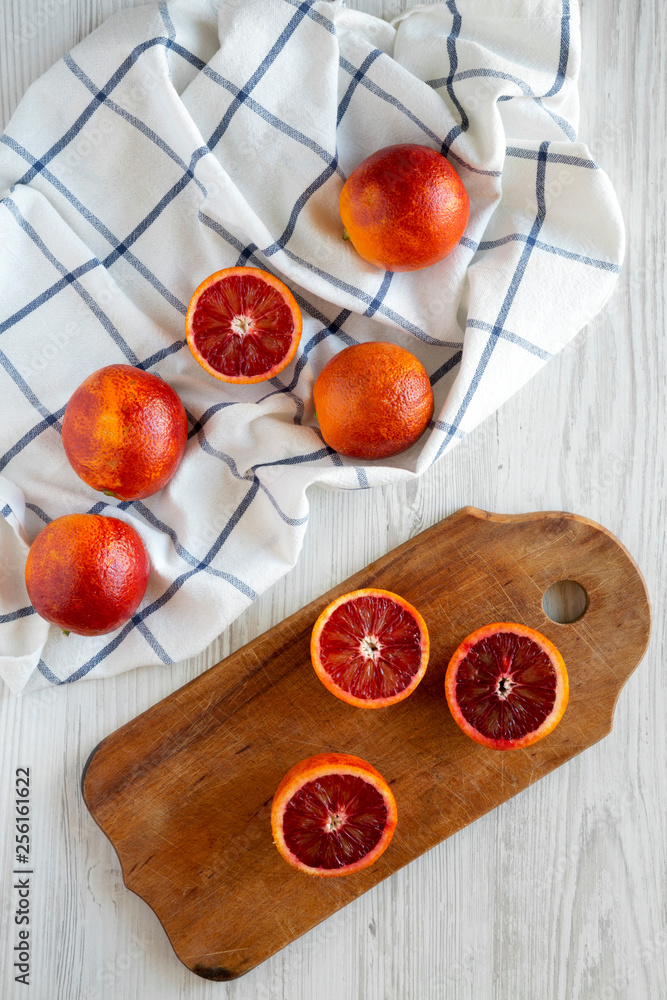 Whole and halved blood oranges, top view. Flat lay, overhead, from above. Whole and halved blood oranges, top view. Flat lay, overhead, from above.