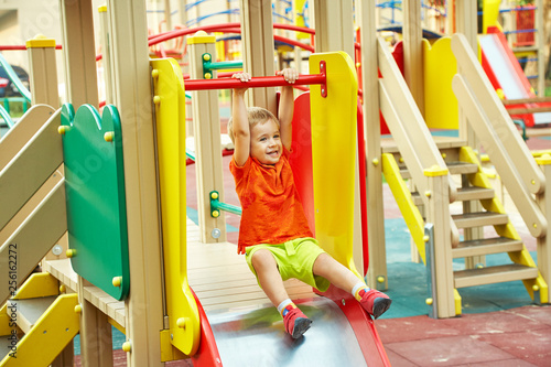 little boy on playground. playing child on slide