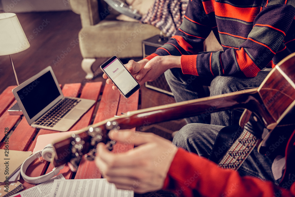 Close up of two musicians searching for some melody in the Internet