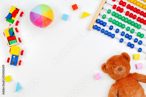 Baby kids toys background with teddy bear, wooden train,toy abacus and colorful blocks. Top view, flat lay photo