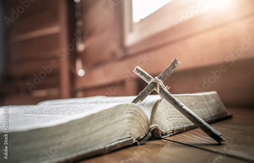 Close up of wooden cross with old bible. christian concept.