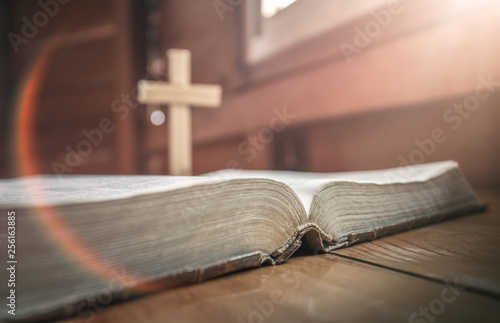 Photography Close up of old holy bible with christian cross standing at background