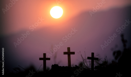 Three cross standing with light sunset background. christian silhouette concept