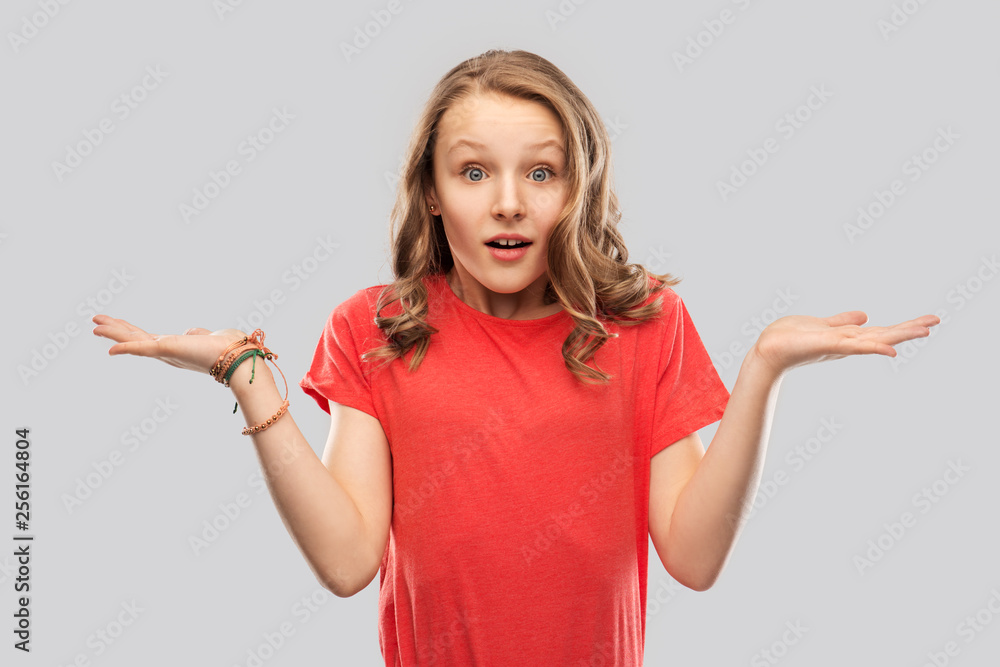 people, emotion and expression concept - wondering teenage girl in red t-shirt shrugging over grey background people, emotion and expression concept - wondering teenage girl in red t-shirt shrugging over grey background