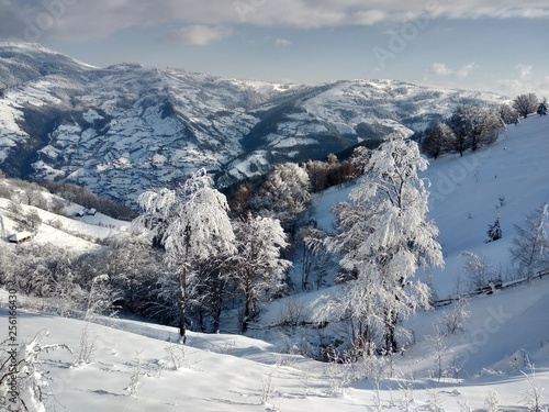Paisaje de invierno con montañas y nieve en Rumania, pueblo de Parva, Transilvania © nykaly