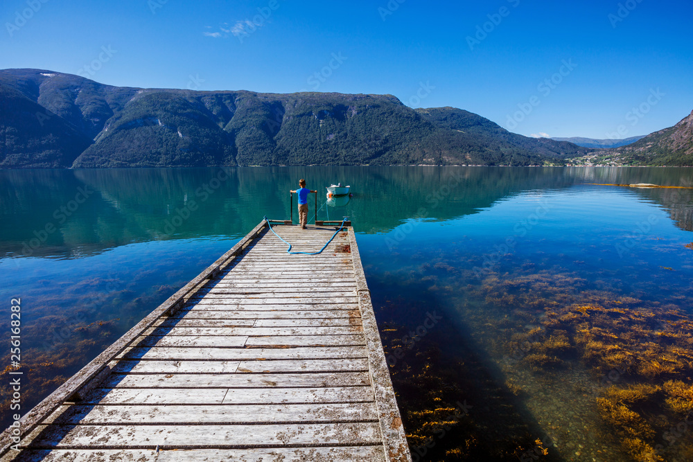 Beautiful Nature Norway natural landscape with pier for boats, fjord and mountain.