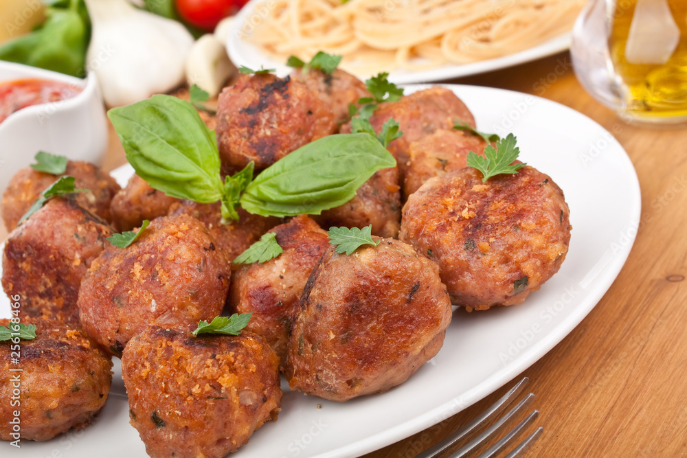 chicken meatballs  on a plate with basil and spaghetti