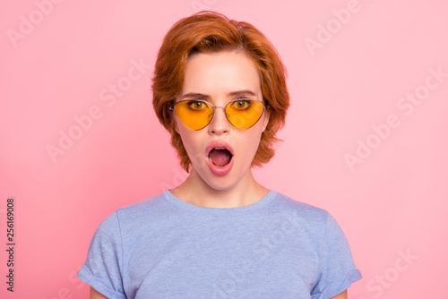 Close-up portrait of her she nice cute charming attractive winsome stunned girl wearing casual blue t-shirt yellow glasses opened mouth isolated over pink pastel background