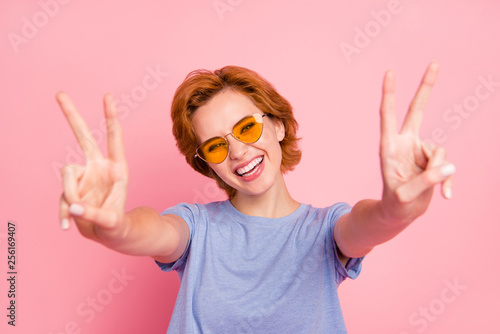 Close-up portrait of her she nice cute charming adorable attractive lovely cheerful optimistic girl wearing casual blue t-shirt yellow glasses giving you double v-sign isolated over pink background photo
