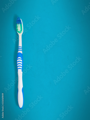 Blue toothbrush on paper blue background