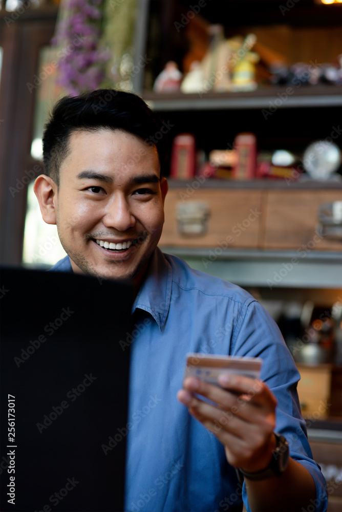 Making online bank transfer, man holds a credit card while entering data in laptop Making online bank transfer, man holds a credit card while entering data in laptop