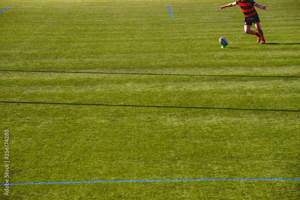 Valencia, Spain - January 19, 2019: Rugby player kicking the ball. Valencia, Spain - January 19, 2019: Rugby player kicking the ball.