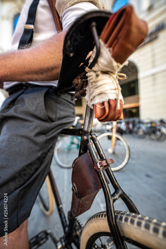 Ciclista appoggiato alla bicicletta con pneumatico di scorta sotto il sellino photo